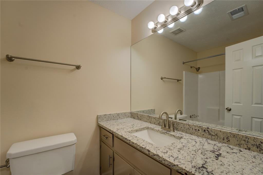 170 Hidden Pines Drive Covington, GA 30016 - Photo 17 of 22 a bathroom with a granite countertop sink a toilet and a mirror