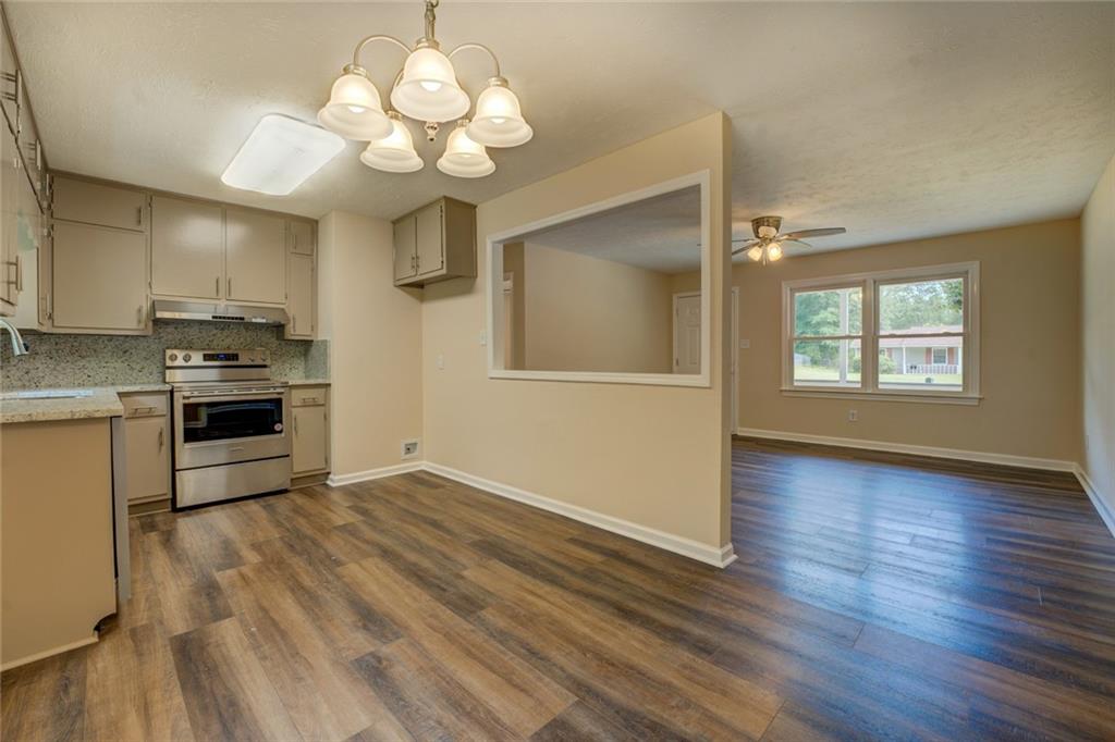 170 Hidden Pines Drive Covington, GA 30016 - Photo 6 of 22 a view of a kitchen with a stove wooden cabinet wooden floor and a chandelier