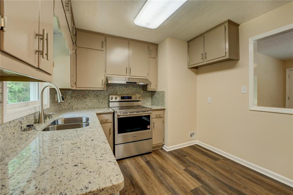 170 Hidden Pines Drive Covington, GA 30016 - Photo 7 of 22 a kitchen with granite countertop a stove a sink and a microwave
