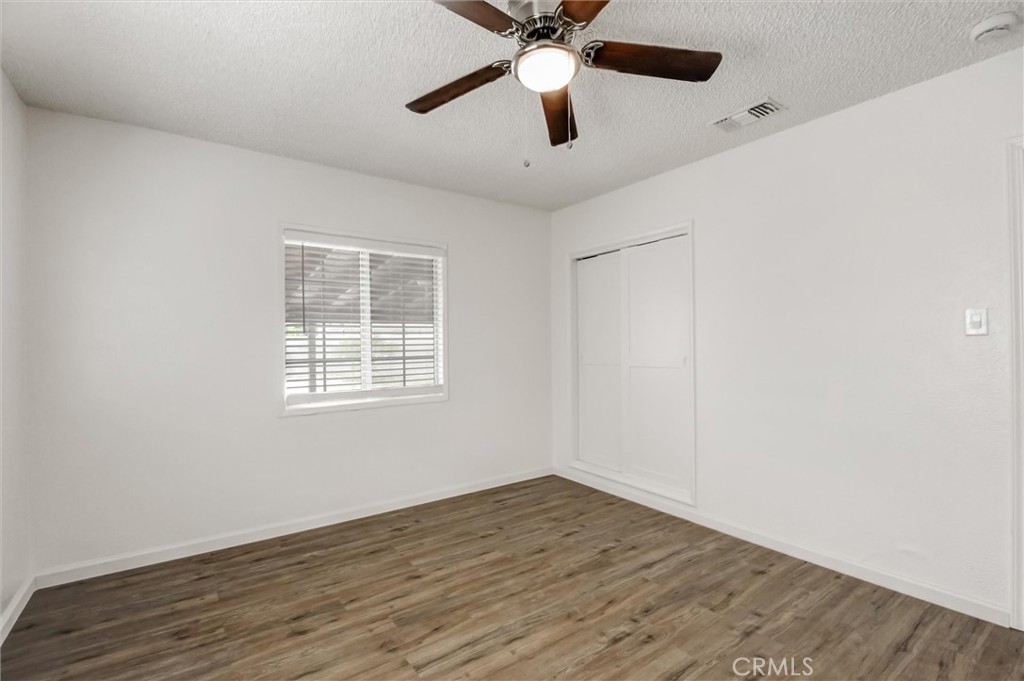 2734 Serrano Road North San Bernardino, CA 92405 - Photo 12 of 25 wooden floor in an empty room with a window