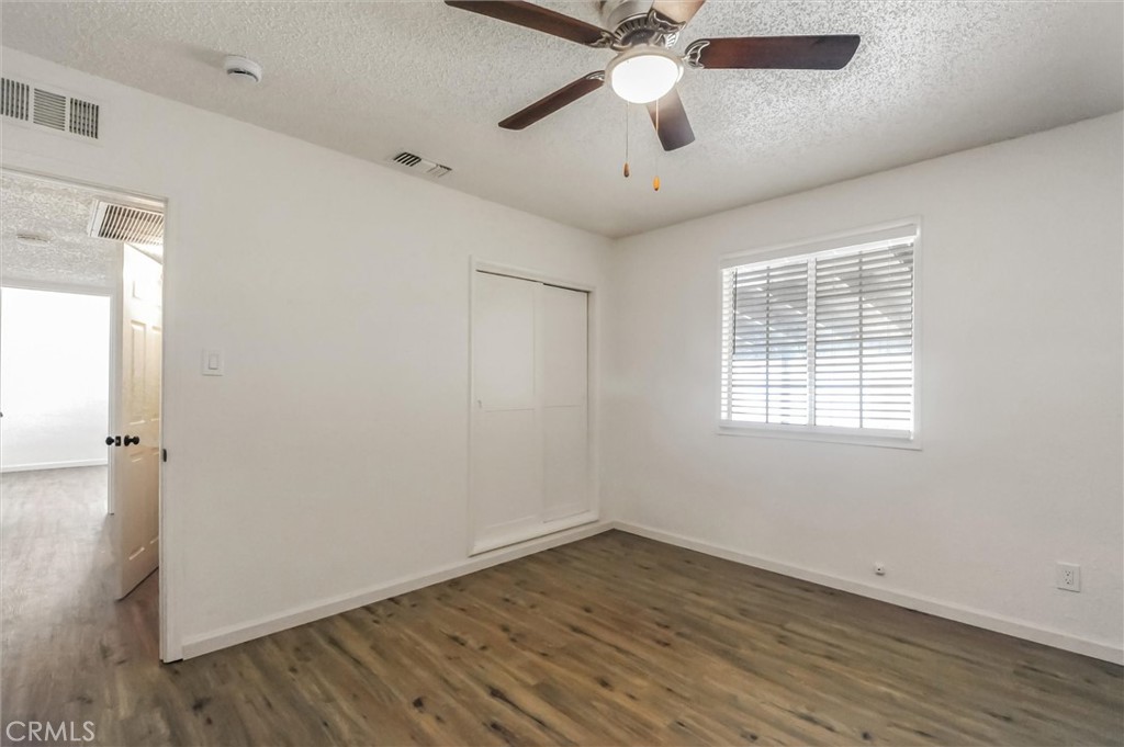 2734 Serrano Road North San Bernardino, CA 92405 - Photo 15 of 25 wooden floor in an empty room with a window