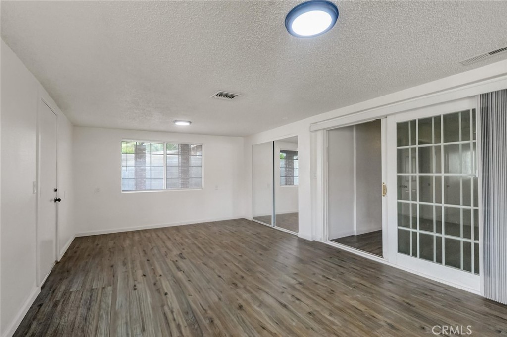2734 Serrano Road North San Bernardino, CA 92405 - Photo 17 of 25 an empty room with wooden floor and windows