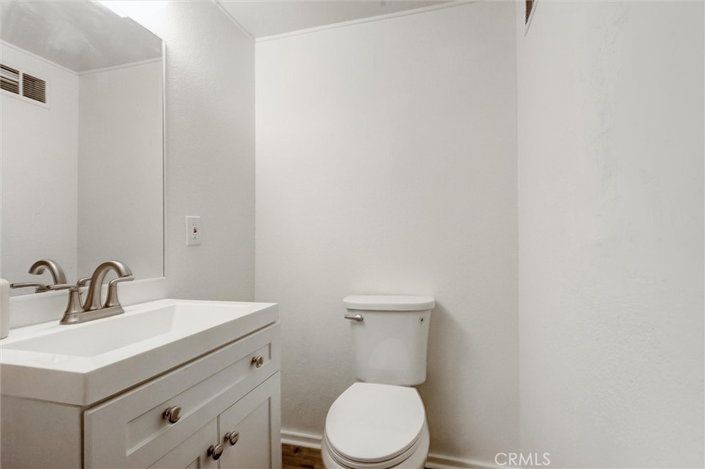 2734 Serrano Road North San Bernardino, CA 92405 - Photo 18 of 25 a bathroom with a toilet a sink and mirror