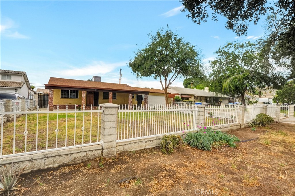 2734 Serrano Road North San Bernardino, CA 92405 - Photo 2 of 25 a front view of a house with a garden