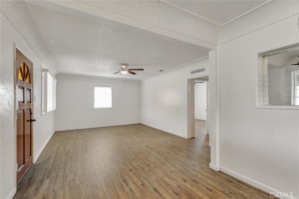 2734 Serrano Road North San Bernardino, CA 92405 - Photo 4 of 25 an empty room with wooden floor and windows