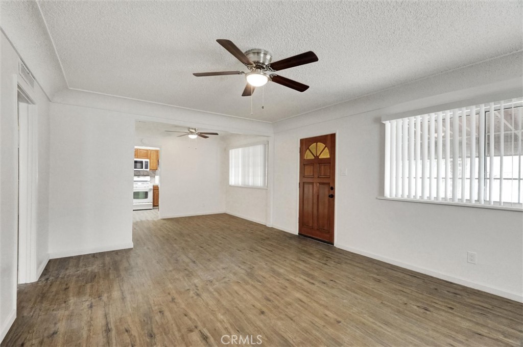 2734 Serrano Road North San Bernardino, CA 92405 - Photo 5 of 25 a view of an empty room with window and wooden floor