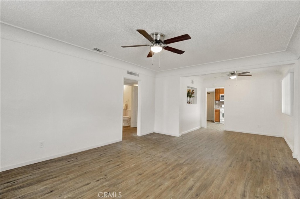2734 Serrano Road North San Bernardino, CA 92405 - Photo 6 of 25 a view of a livingroom with wooden floor and a ceiling fan