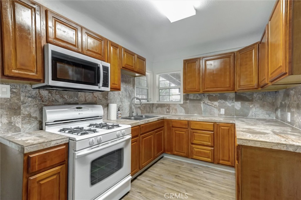 2734 Serrano Road North San Bernardino, CA 92405 - Photo 7 of 25 a kitchen with granite countertop cabinets stainless steel appliances and a sink