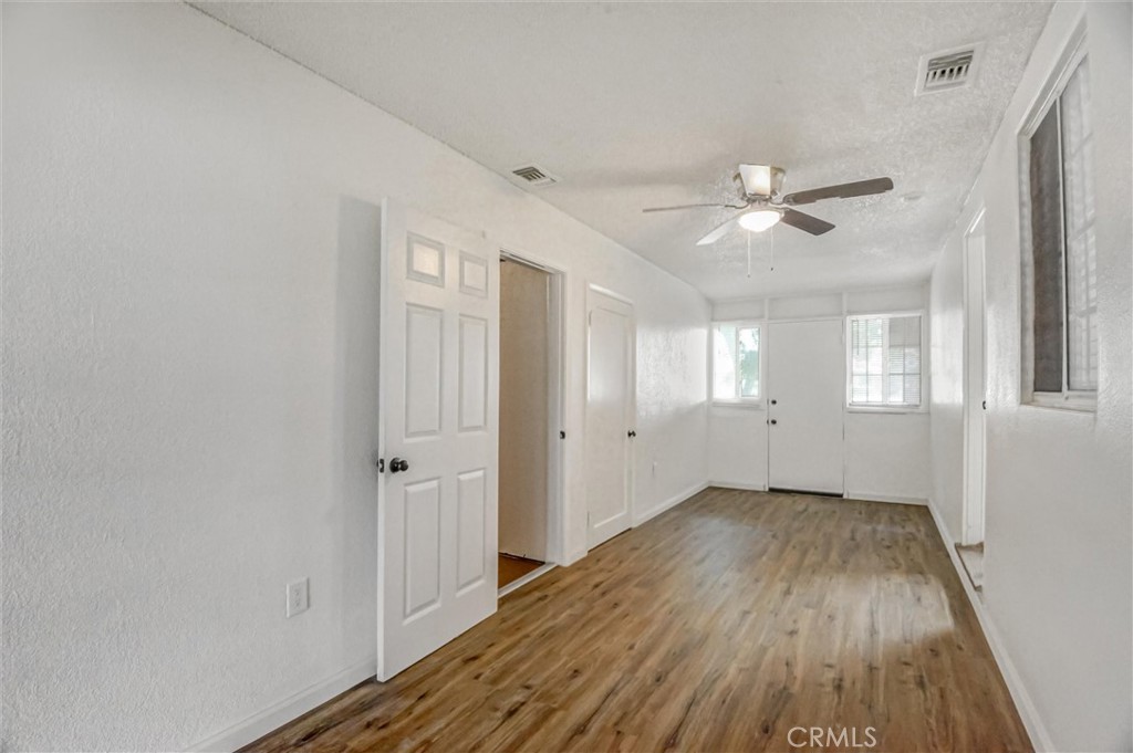 2734 Serrano Road North San Bernardino, CA 92405 - Photo 10 of 25 wooden floor in an empty room with a window