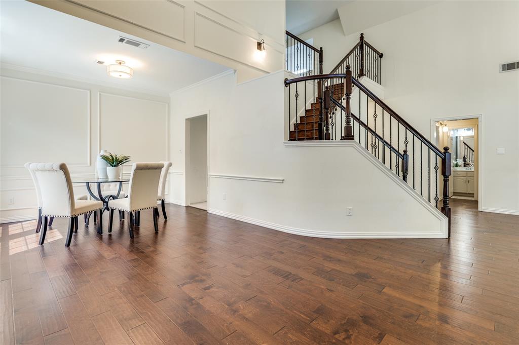 3840 Azure Lane Addison, TX 75001 - Photo 5 of 36 Dining room featuring dark wood-style flooring, a high ceiling, crown molding, stairway, and a decorative wall