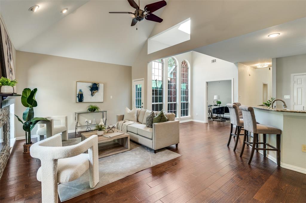 3840 Azure Lane Addison, TX 75001 - Photo 8 of 36 Living area with high vaulted ceiling, dark wood-style flooring, a ceiling fan, a glass covered fireplace, and recessed lighting