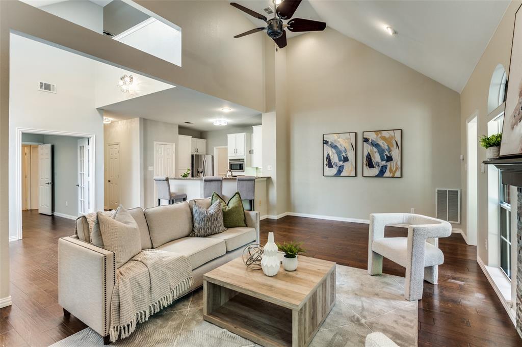 3840 Azure Lane Addison, TX 75001 - Photo 9 of 36 Living room with high vaulted ceiling, hardwood / wood-style flooring, a fireplace, and a ceiling fan