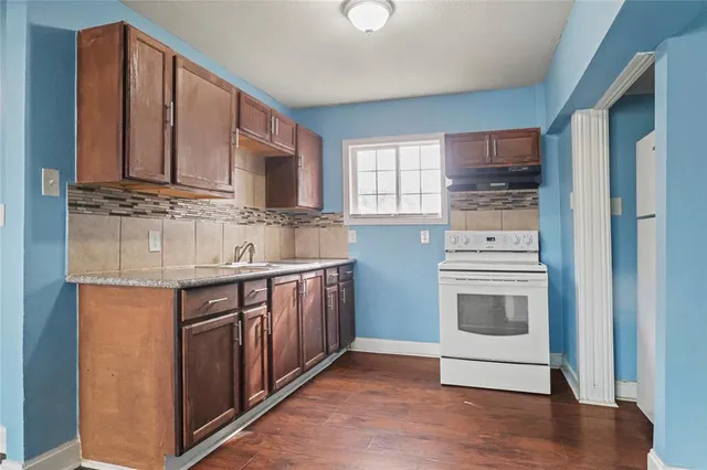 a kitchen with stainless steel appliances granite countertop a sink stove and cabinets