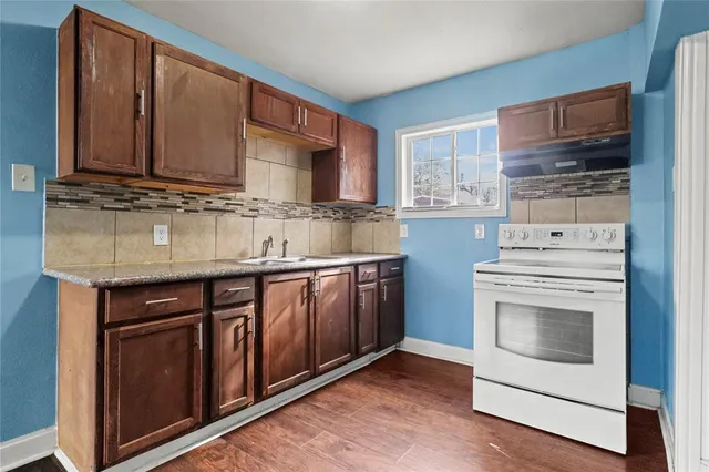 a kitchen with stainless steel appliances granite countertop a sink stove and cabinets