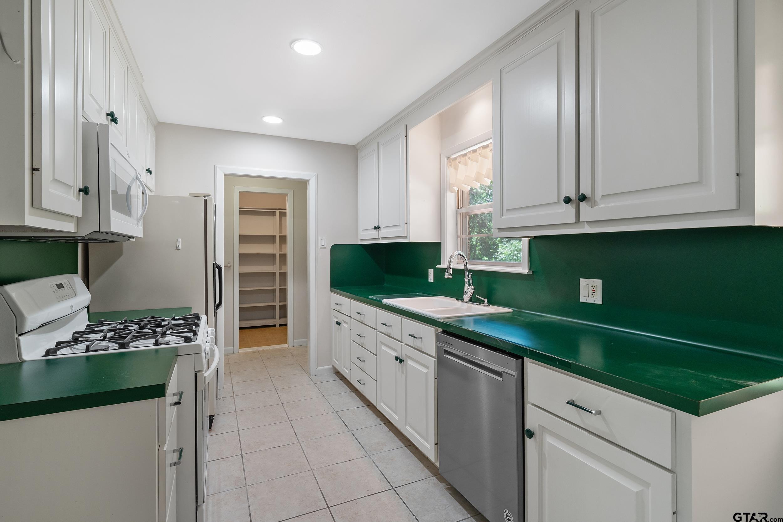 2026 Neeley Street Tyler, TX 75701 - Photo 7 of 26 a kitchen with stainless steel appliances kitchen island granite countertop a sink stove and cabinets