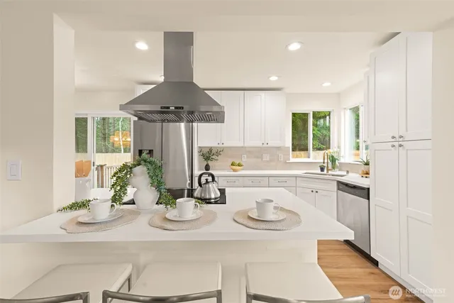a kitchen with a sink a counter top space stainless steel appliances and cabinets
