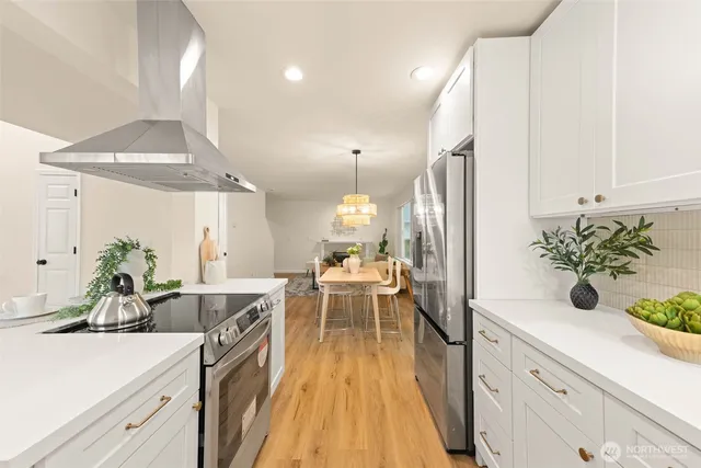 a view of a dining room and livingroom with furniture wooden floor a chandelier