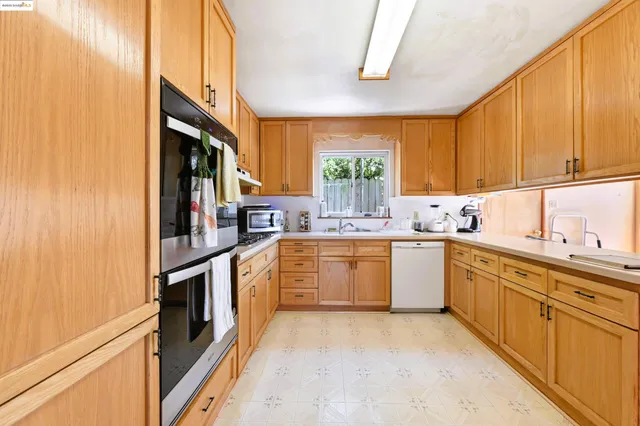 a kitchen with stainless steel appliances granite countertop a sink a stove and refrigerator
