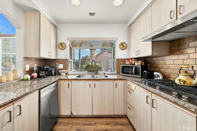 a kitchen with granite countertop a sink and a stove