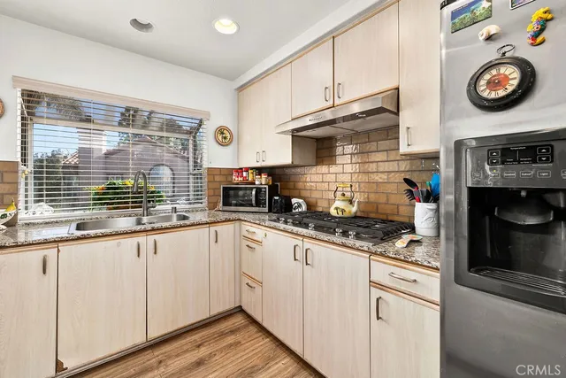 a kitchen with granite countertop a sink stainless steel appliances and cabinets