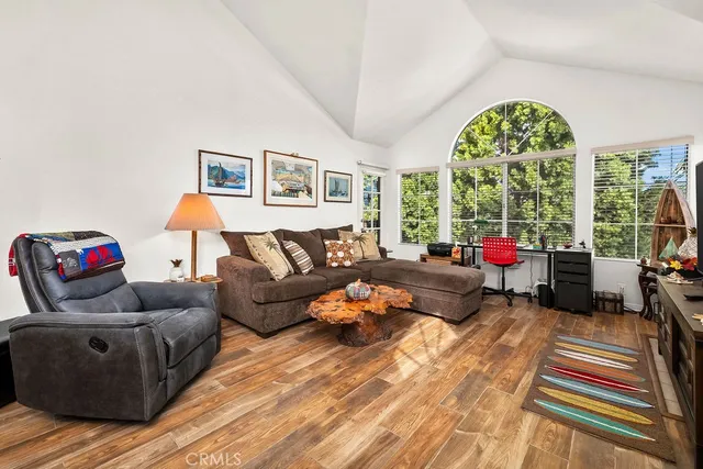 a living room with furniture a flat screen tv and a large window