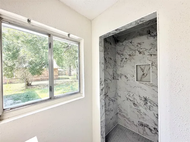 a bathroom with a granite countertop toilet a sink and a window
