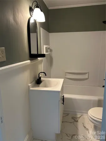 a bathroom with a sink a toilet and mirror