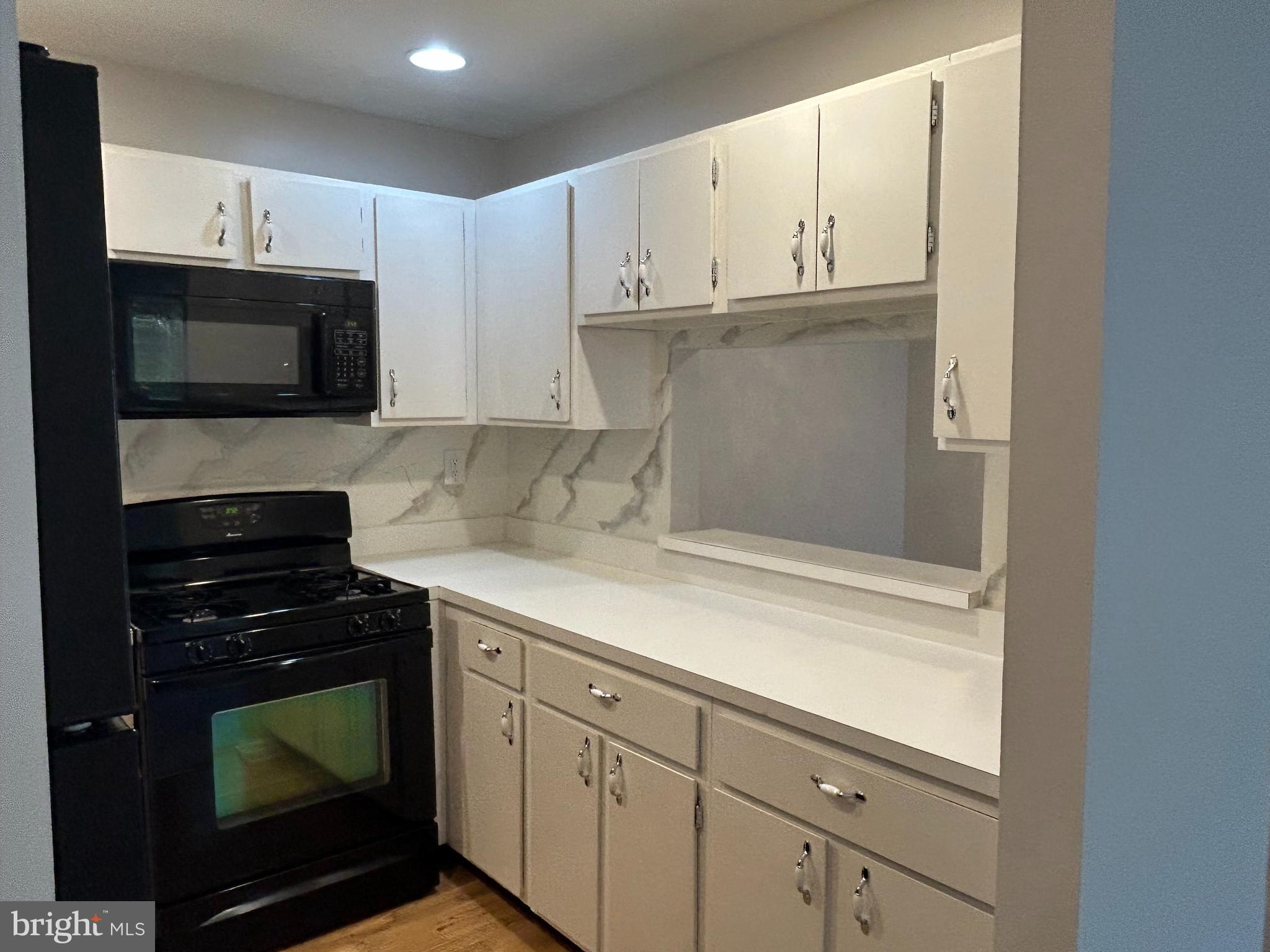 35 Coral Tree Court Lawrence Township, NJ 08648 - Photo 7 of 13 a kitchen with granite countertop white cabinets and black appliances
