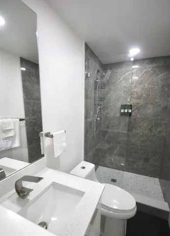 a bathroom with a sink a toilet and shower