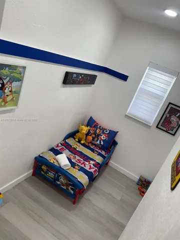 a bedroom with bed and a wooden floor