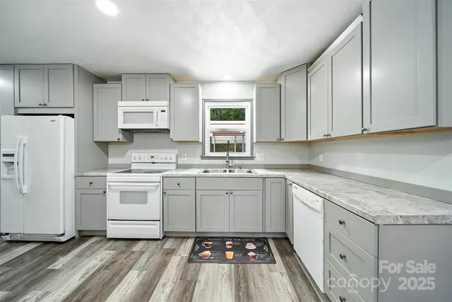 a kitchen with white cabinets sink and white appliances