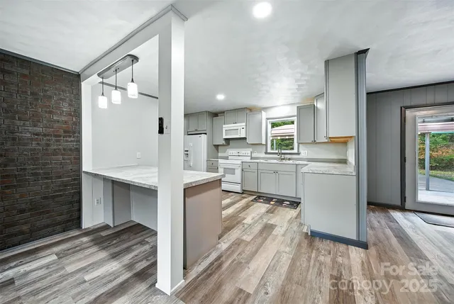 a view of kitchen with sink and refrigerator