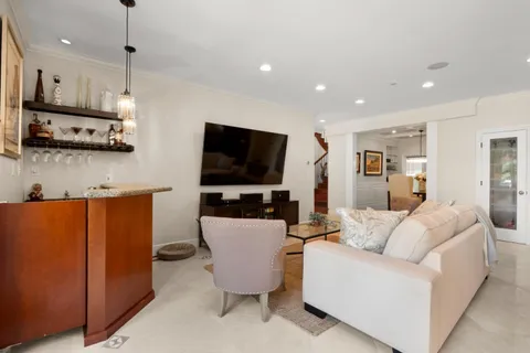 a dining room with stainless steel appliances kitchen island granite countertop a table chairs and a refrigerator