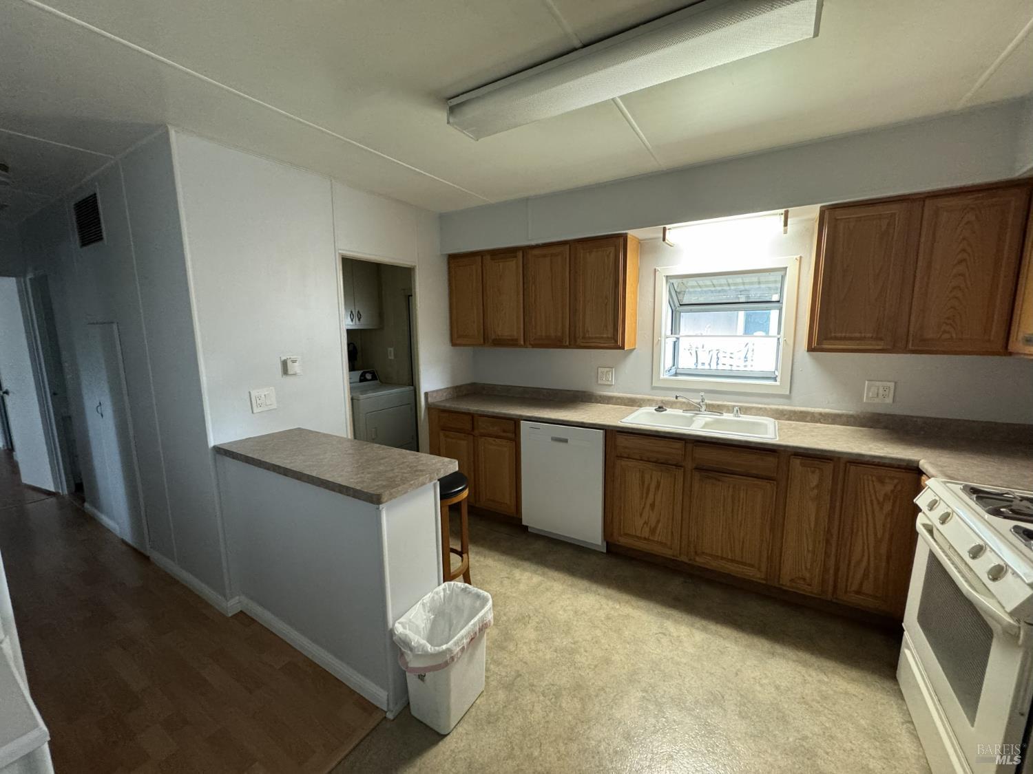 150 Silverado Trail, Unit 29 Napa, CA 94559 - Photo 12 of 18 a kitchen with granite countertop a sink a stove a refrigerator a cabinets wooden floor and a window