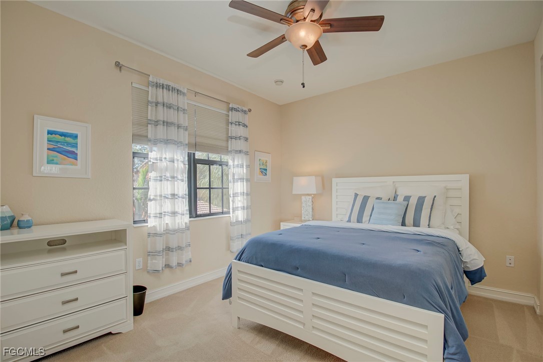 11856 Rocio Street, Unit 2003 Fort Myers, FL 33912 - Photo 21 of 43 a spacious bedroom with a bed and a chandelier