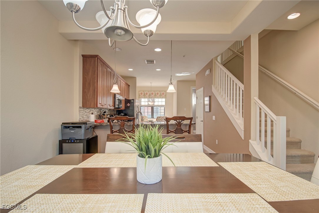 11856 Rocio Street, Unit 2003 Fort Myers, FL 33912 - Photo 7 of 43 a view of a dining room and livingroom with furniture wooden floor a rug a potted plant and a chandelier