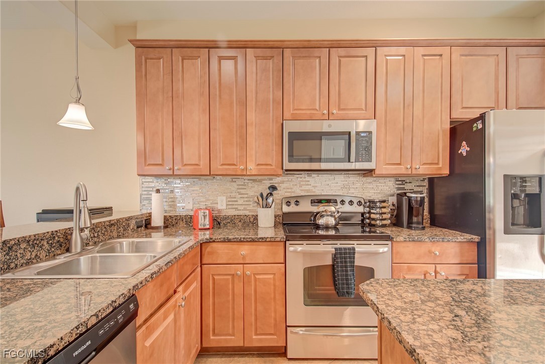 11856 Rocio Street, Unit 2003 Fort Myers, FL 33912 - Photo 8 of 43 a kitchen with stainless steel appliances granite countertop a stove a sink and a microwave