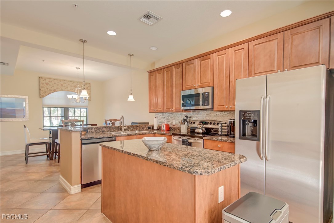 11856 Rocio Street, Unit 2003 Fort Myers, FL 33912 - Photo 10 of 43 a kitchen with granite countertop stainless steel appliances a refrigerator a stove top oven and a center island