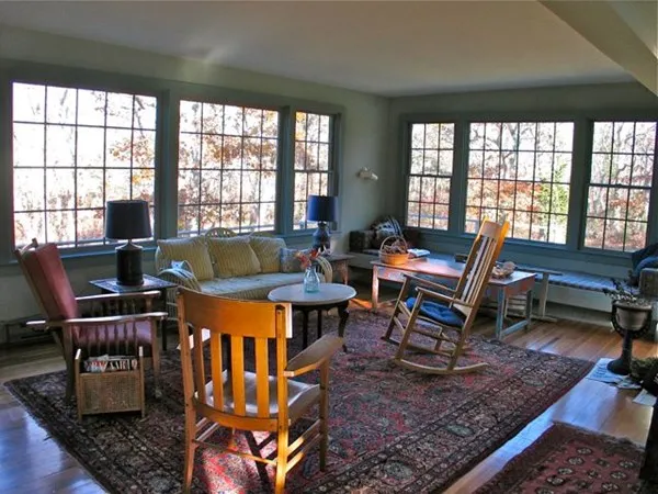 a living room with furniture a rug and a floor to ceiling window