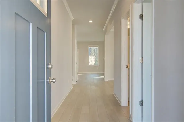 a view of a hallway with wooden floor and closet area