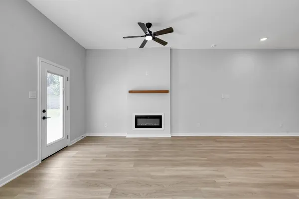 a view of a livingroom with wooden floor and a ceiling fan