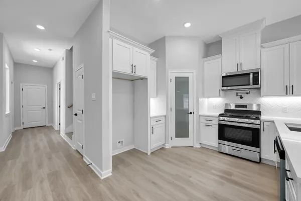 a kitchen with stainless steel appliances a stove a refrigerator and a microwave