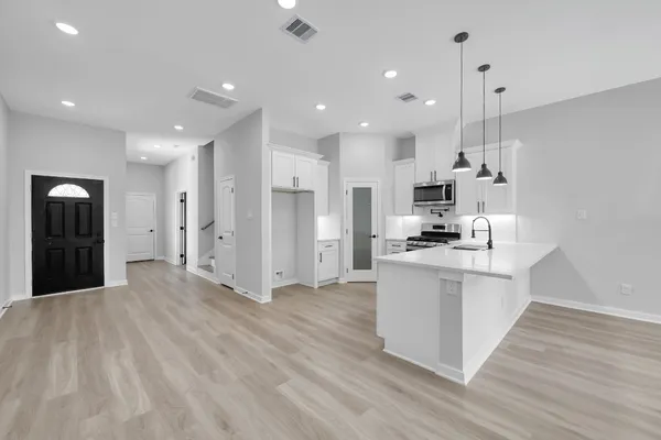 a view of kitchen with stainless steel appliances refrigerator oven and cabinets
