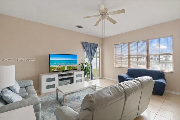 a living room with furniture a ceiling fan and a window
