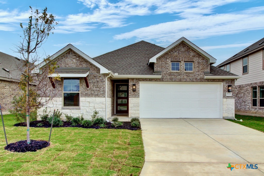 a front view of a house with a yard and garage