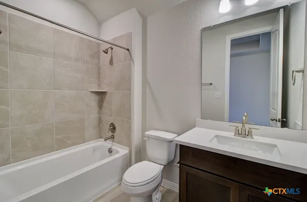 a bathroom with a sink a toilet a mirror a bathtub and shower