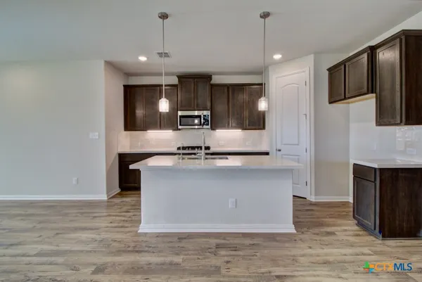a kitchen with kitchen island a sink stainless steel appliances and cabinets