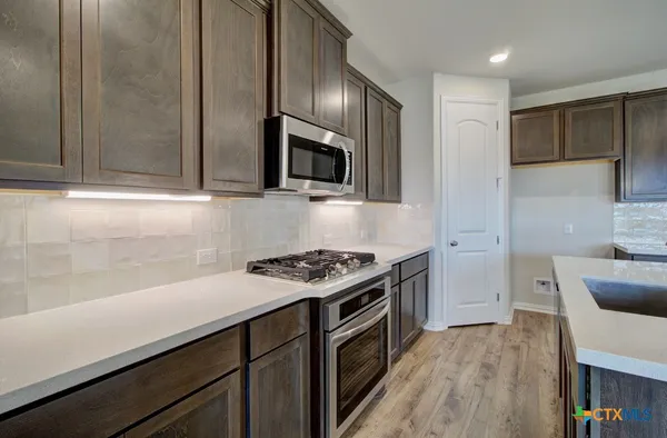 a kitchen with stainless steel appliances a stove a sink and a microwave
