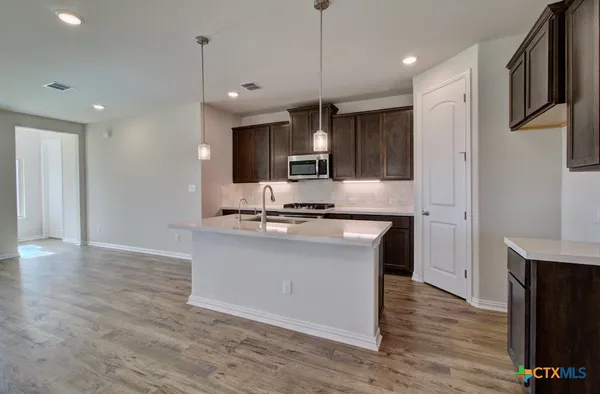a kitchen with kitchen island a sink stainless steel appliances and cabinets