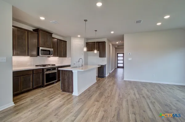 a large kitchen with stainless steel appliances kitchen island granite countertop a large counter top and stainless steel appliances